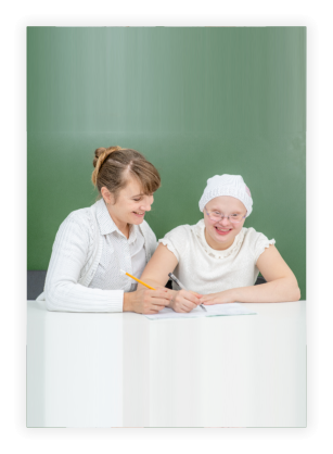 Teacher helps young girl with Down Syndrome at school