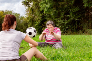 Mental disabled women is throwing a ball to a women to train her motor function